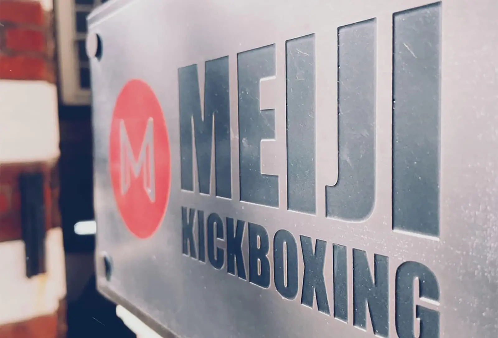 A close up of the Meiji martial arts front door sign