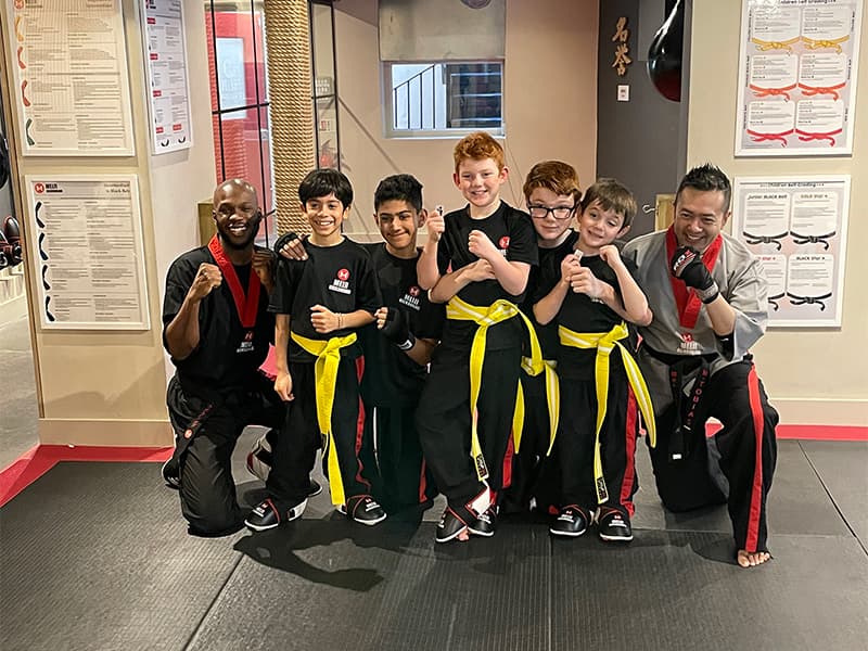 A group of young students showing off their yellow belts