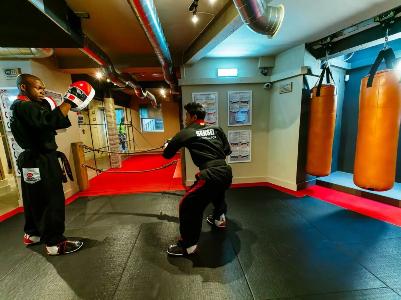 Two Meiji Kickboxing instructors sparring within the St. John's Wood Dojo